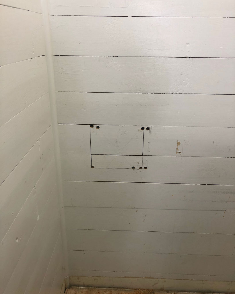wall showing pencil marks and pre-drilled holes.