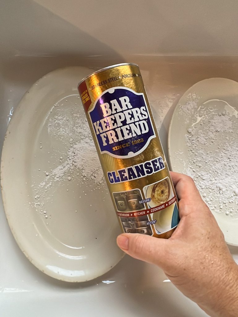 Bar Keepers Friend cleanser with thrifted platters covered in cleanser